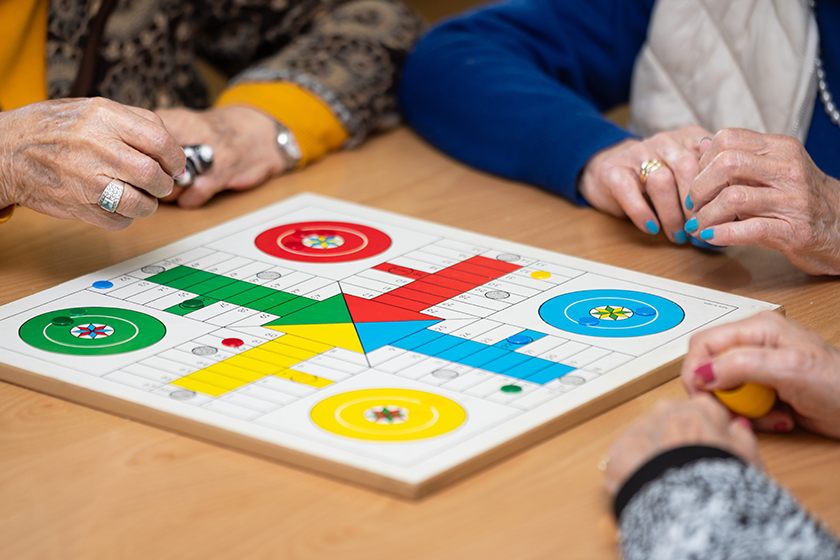 Group of unrecognizable senior woman playing the classic game Ludo